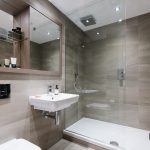 Modern bathroom with a walk-in shower, stylish sink, and contemporary fixtures, showcasing the amenities of the studio apartment at 50 Holland Street, G2 4BD, available for rent.