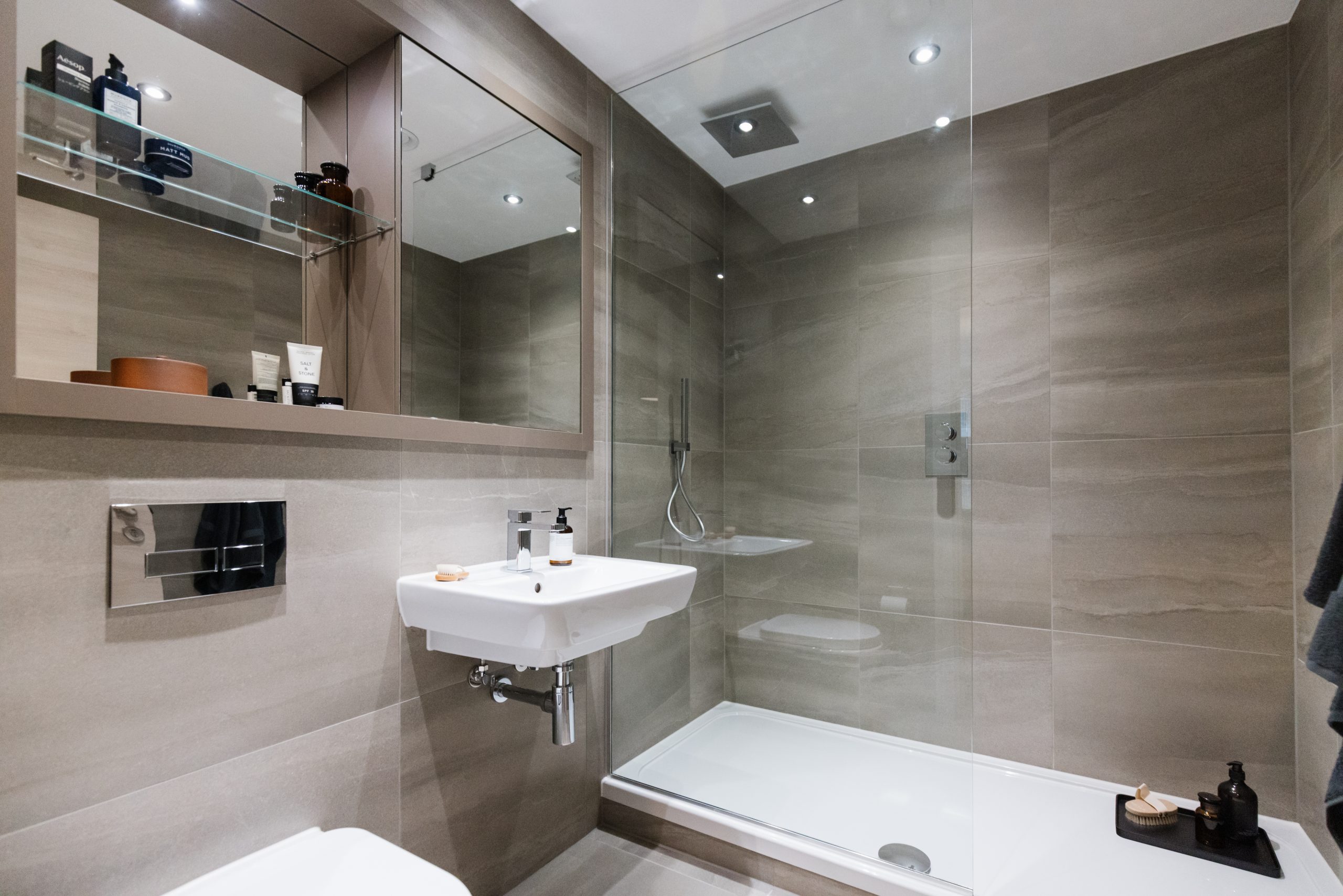 Modern bathroom with glass shower, sleek sink, and stylish storage, featuring amenities ideal for the studio apartment at 50 Holland Street, Glasgow.