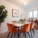 Dining area in a 4-bedroom terraced house, featuring a table set for dining, orange upholstered chairs, and decorative plants, highlighting the unfurnished accommodation available for rent in South Queensferry.