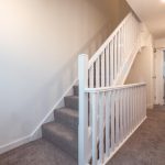 Staircase in unfurnished 4-bedroom terraced house, leading to upper floors, with neutral walls and carpet, located in South Queensferry.