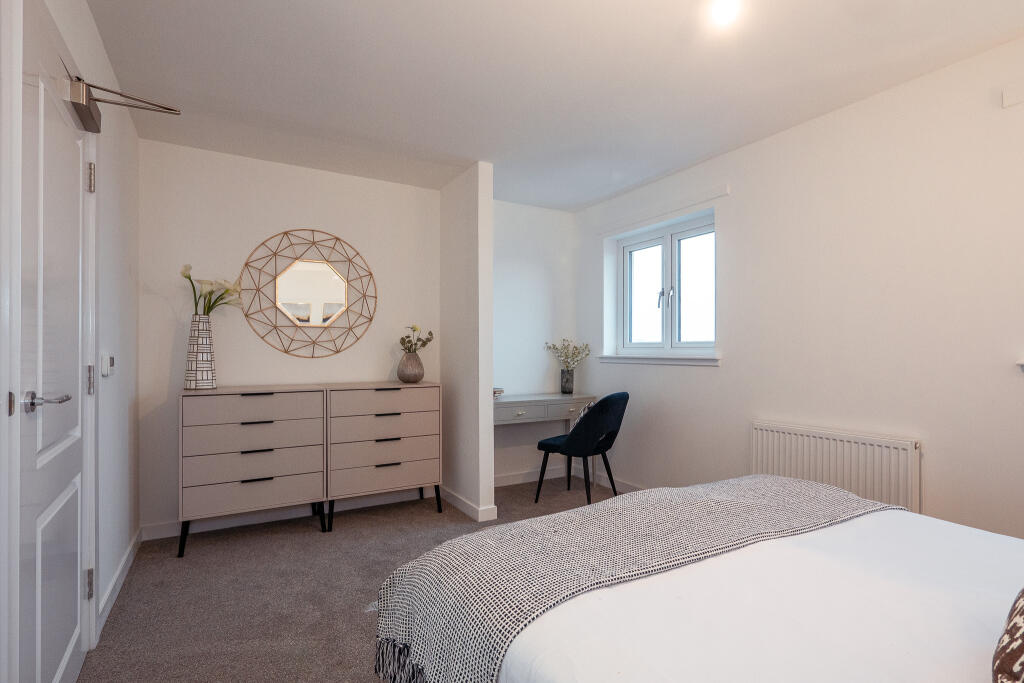 Modern bedroom interior featuring a double bed, stylish dresser, geometric mirror, and a desk with a chair, highlighting the unfurnished 4-bedroom terraced house available for rent in South Queensferry.