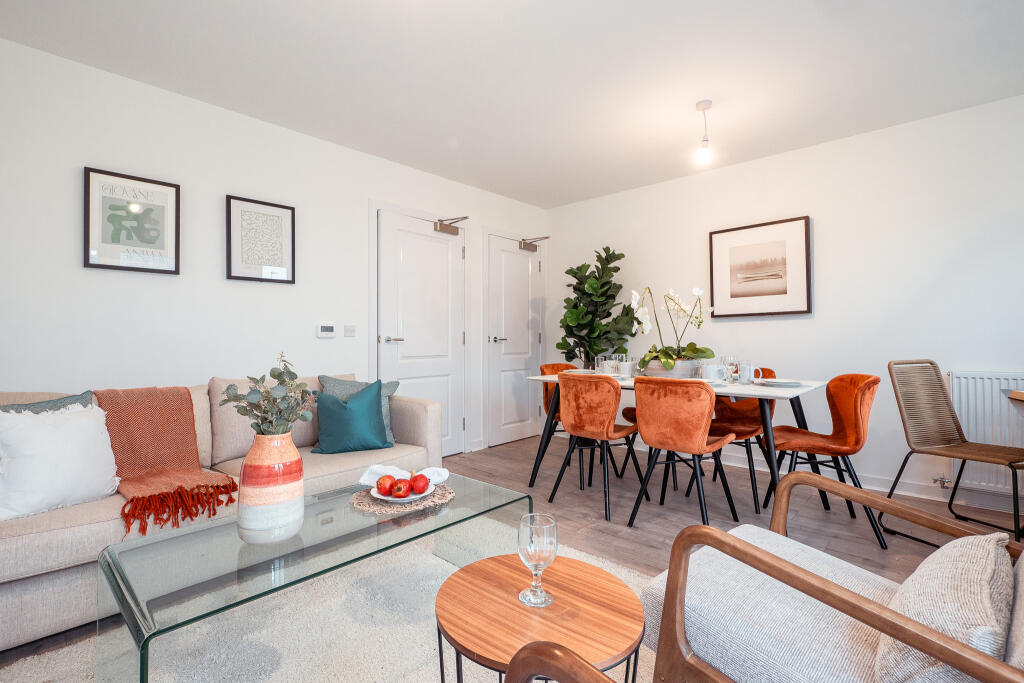 Living and dining area of a 4-bedroom unfurnished terraced house in South Queensferry, featuring modern decor, a glass coffee table, orange dining chairs, and a plant, highlighting spacious accommodation available for rent.